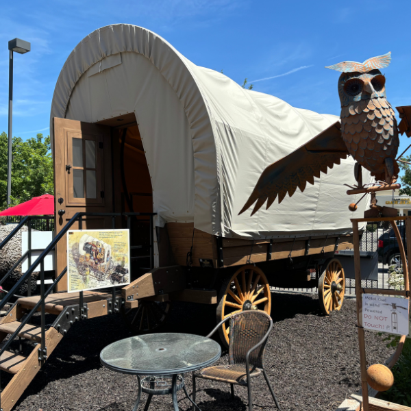 Conestoga Wagon outside with owl sculpture