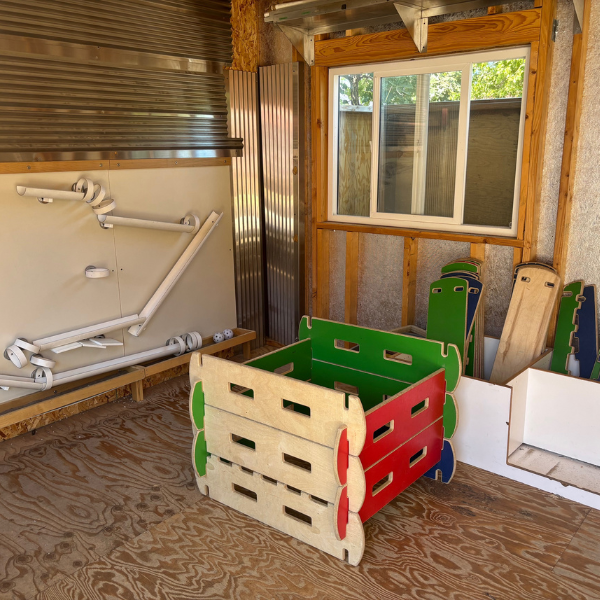 room with giant wooden planks to build structures and magnetic wall with ball ramps and ledges