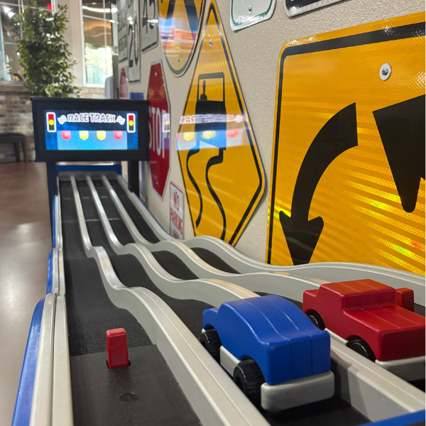 Cars lined up ready to go down a ramp with a timer at the bottom to see who wins