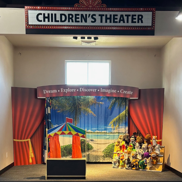 Photo of Kid's theater with puppets, tiny stage, and tables with activities
