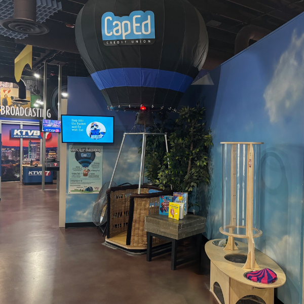 Hot air ballon kids can step inside of next to wind tubes with parachute men