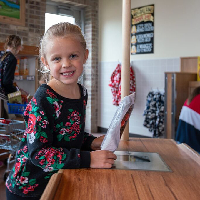 Young Girl smiling while playing at an activity table